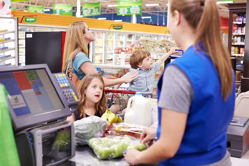 mom at checkout with son grabbing candy