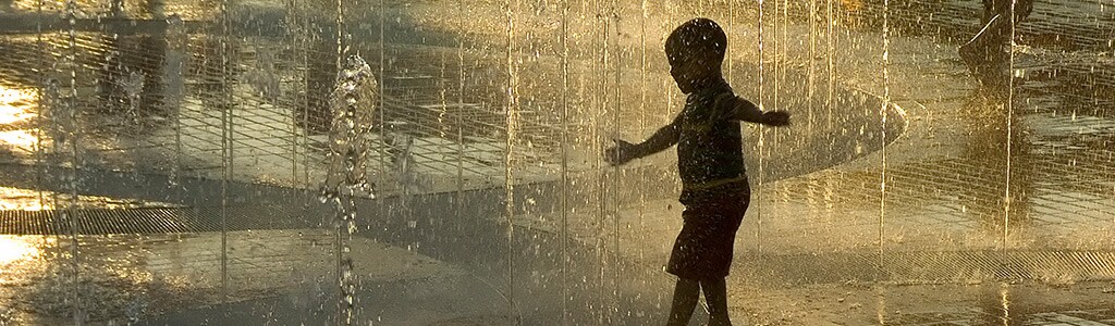 child playing in Centennial Park fountain
