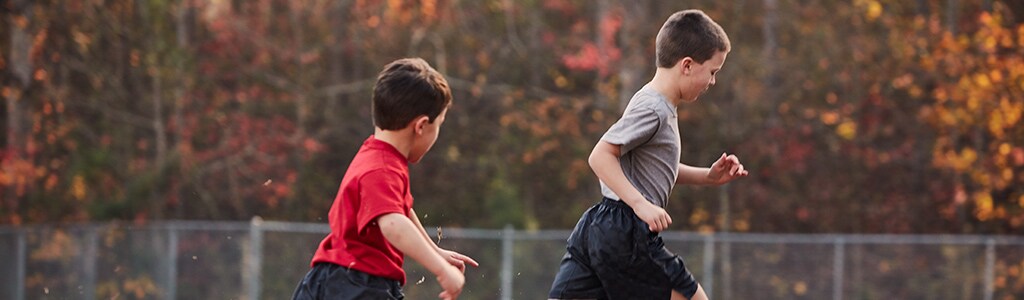 boys playing soccer in park