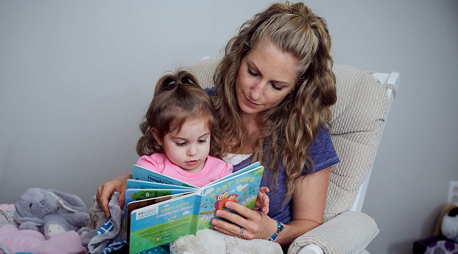 Mom reading a book to her toddler before bed