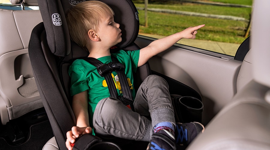 Toddler sitting criss-cross applesauce in rear-facing car seat