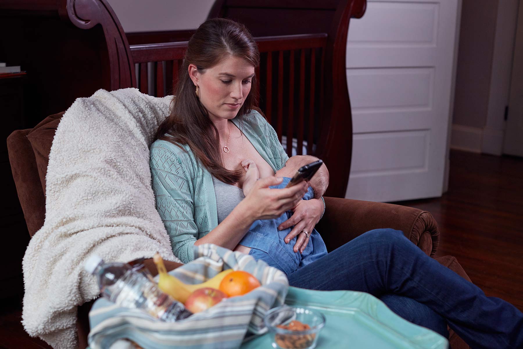 Mom breastfeeding infant while on phone