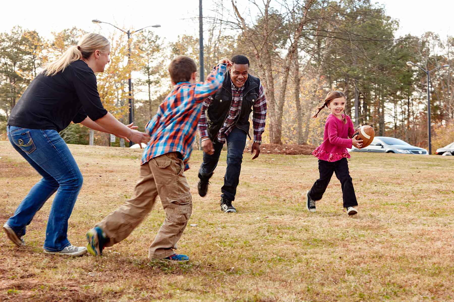 family playing football in park