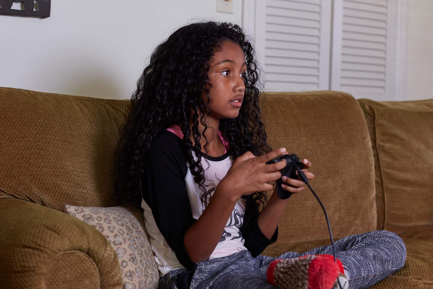 girl playing video games on couch