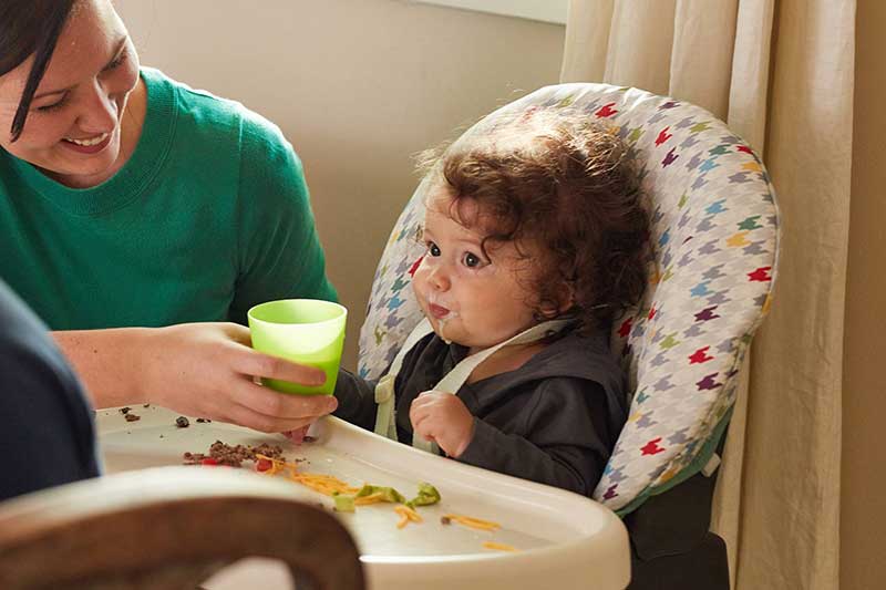 12 month old drinking milk from cup