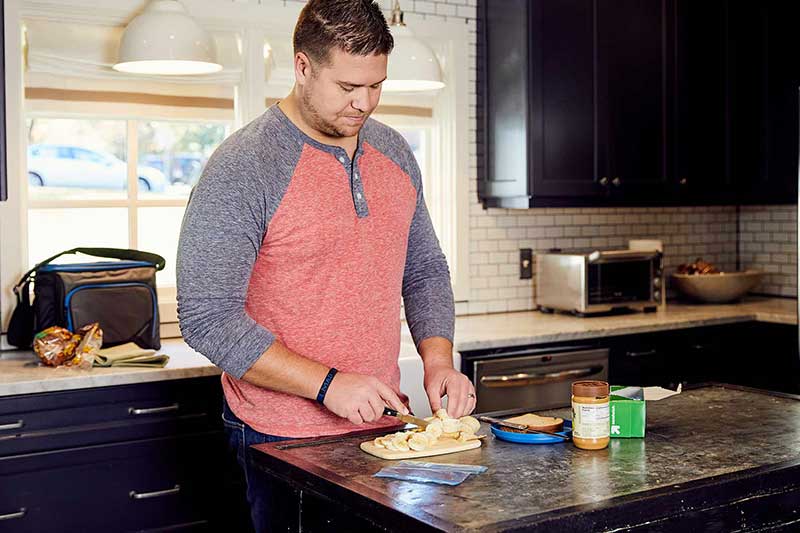dad cutting up peanut butter and banana sandwich