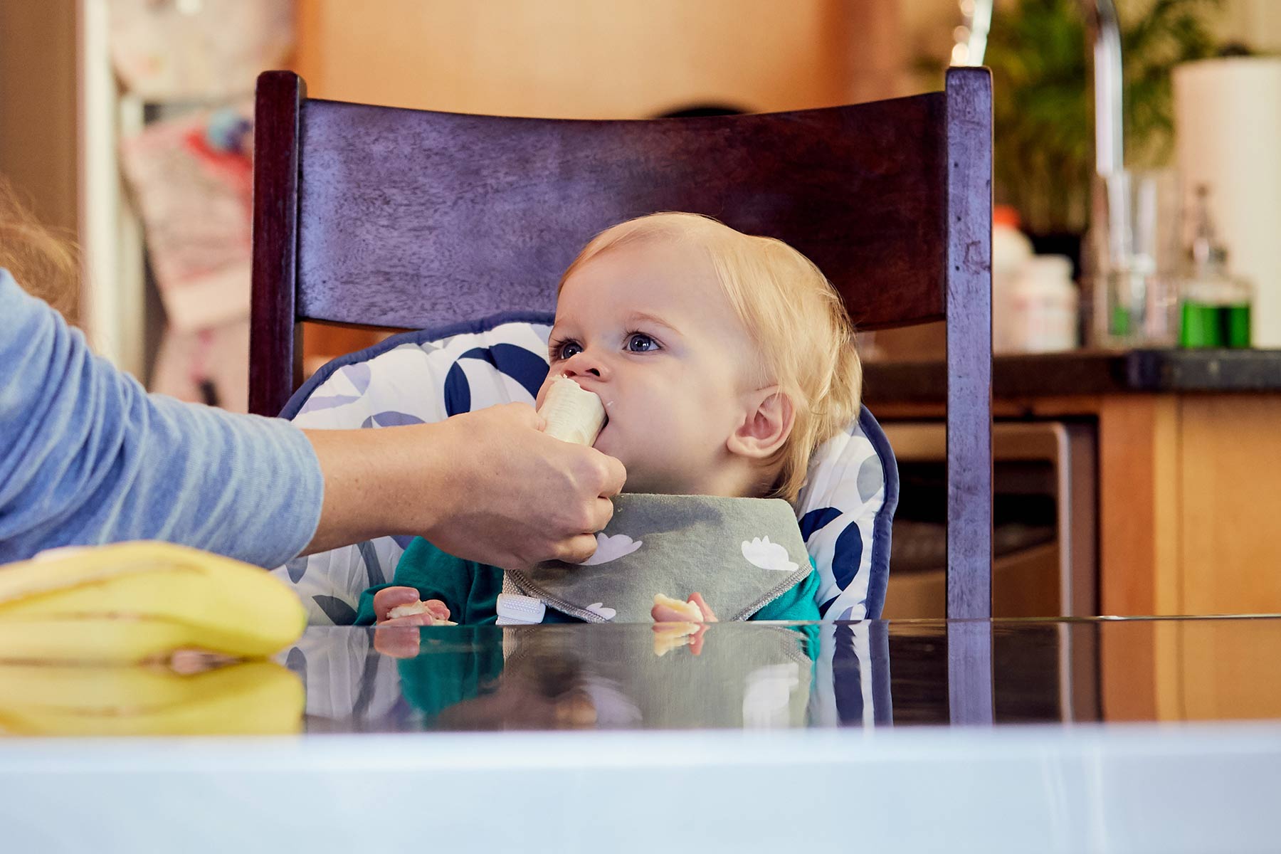 baby taking a bite out out a banana