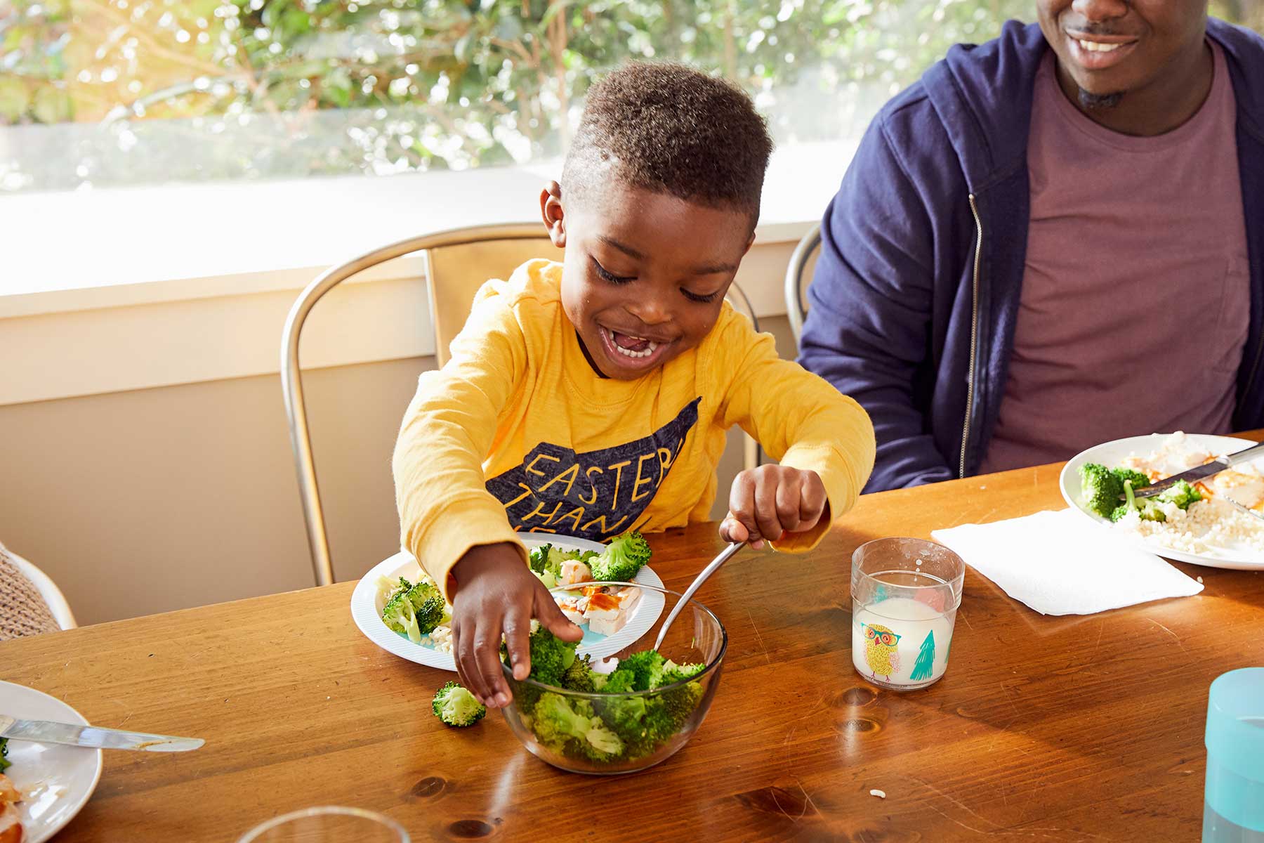 preschooler serving himself at dinner table