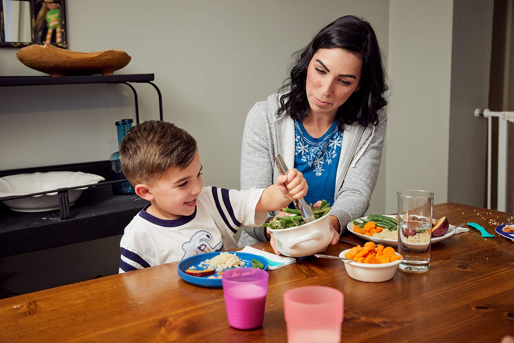 parent offering peas or carrots to preschooler