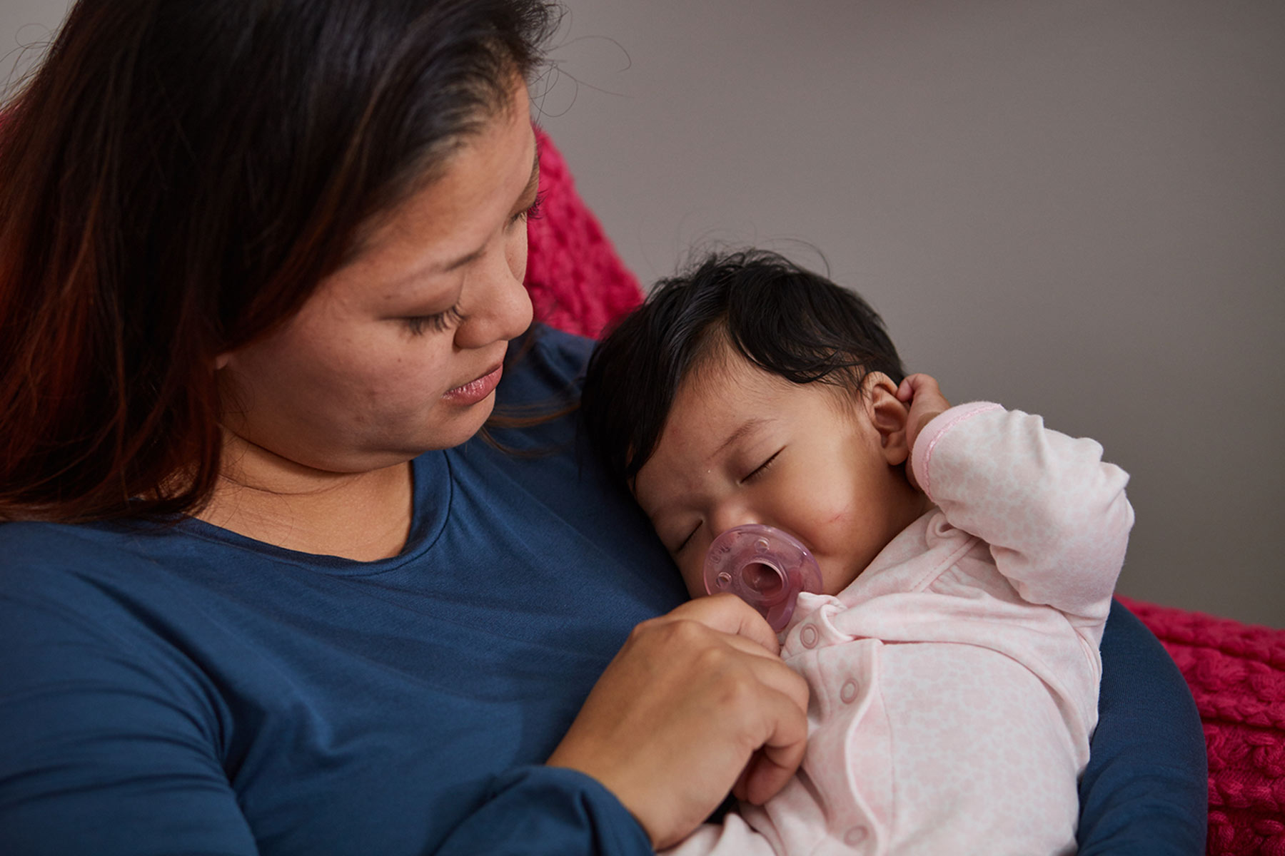 mom holding sleeping baby