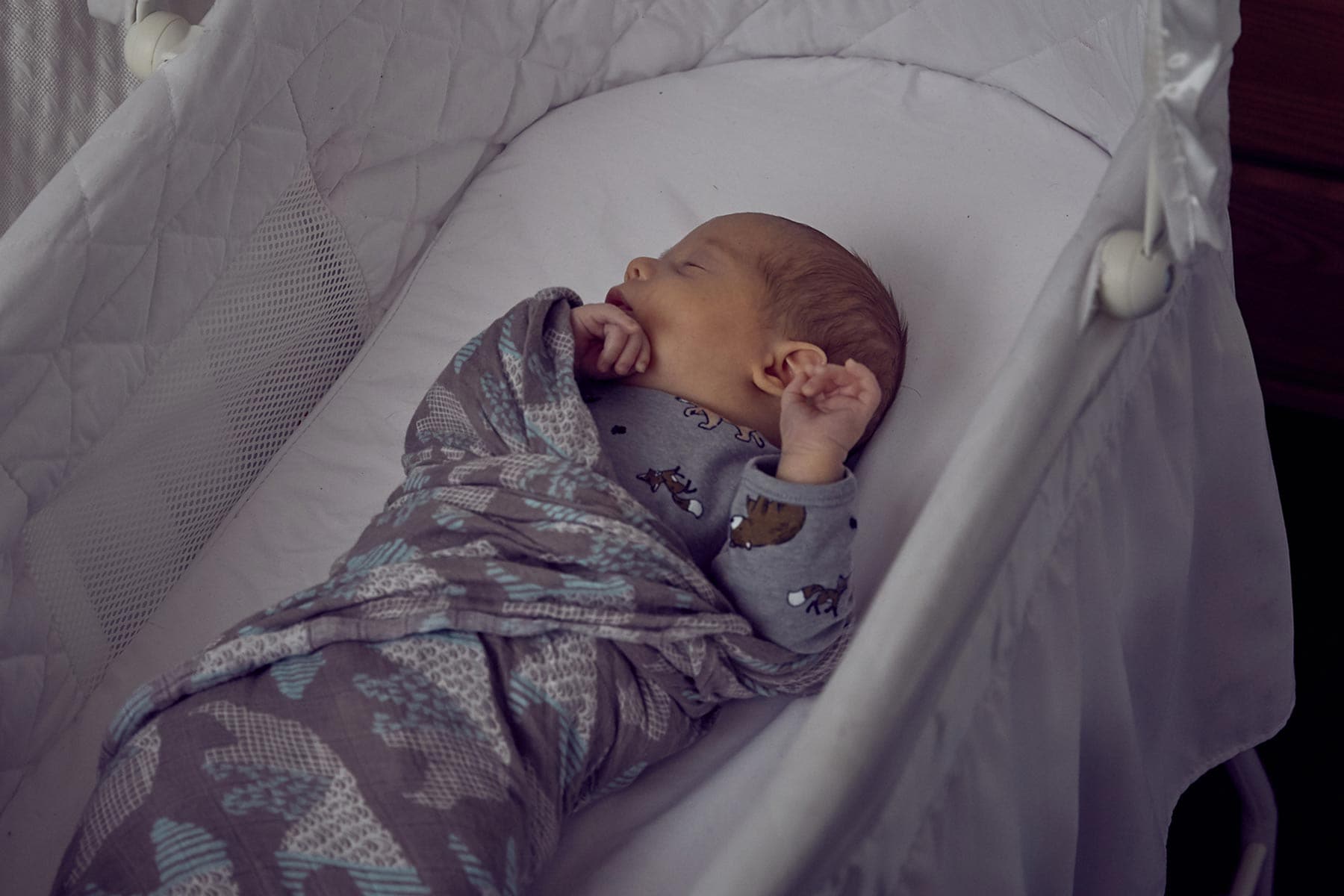 newborn sleeping in bassinet in parents room