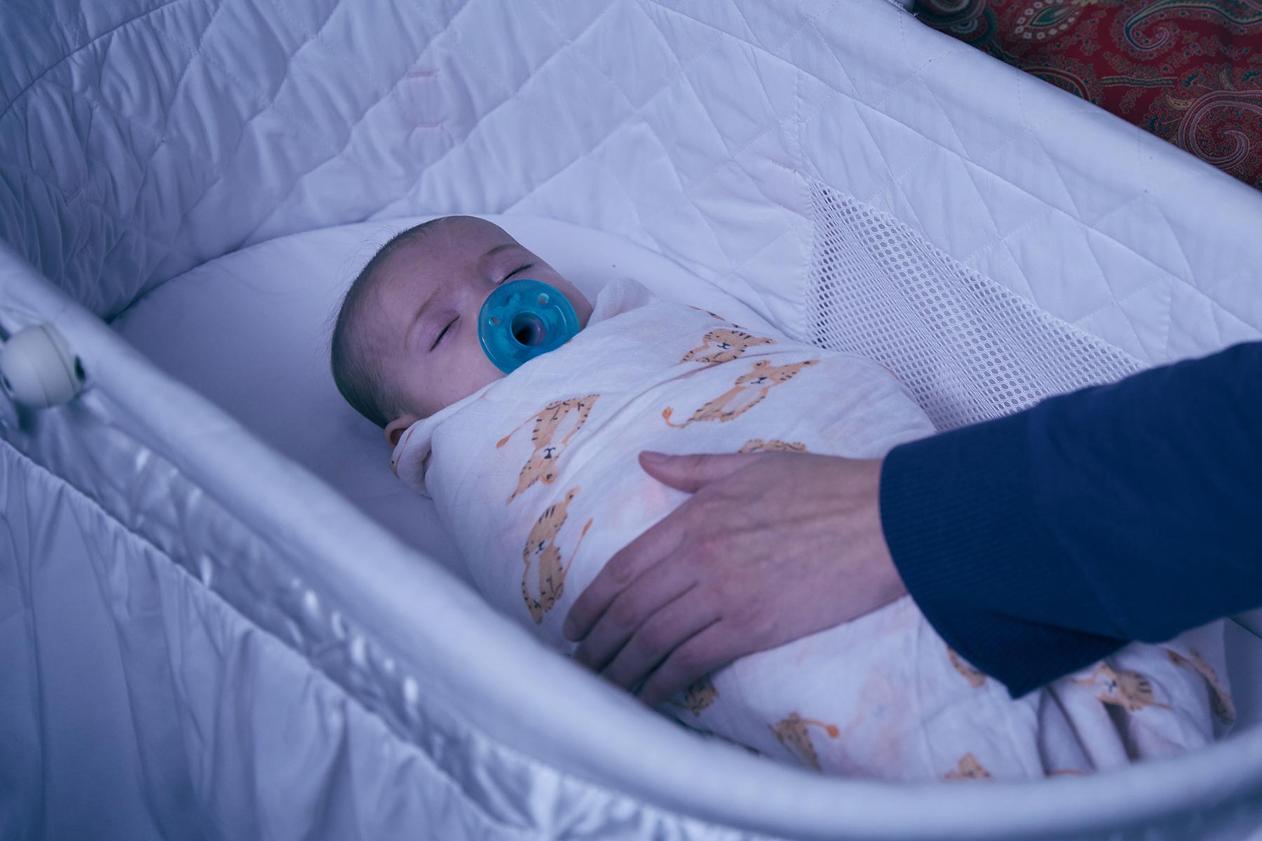 sleeping newborn swaddled with a pacifier