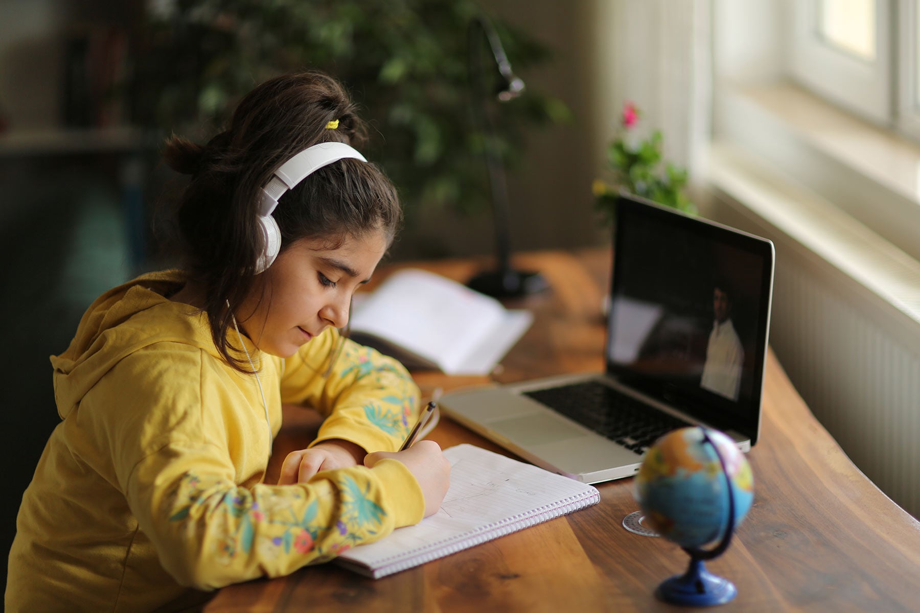 Middle school girl participating in virtual learning at home