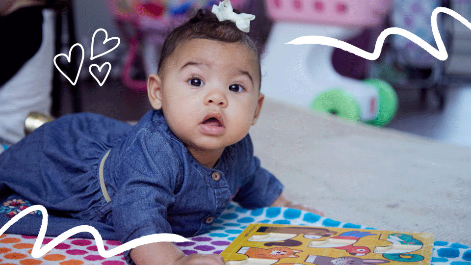 Photo shows baby playing with toy during tummy time at 6 months 