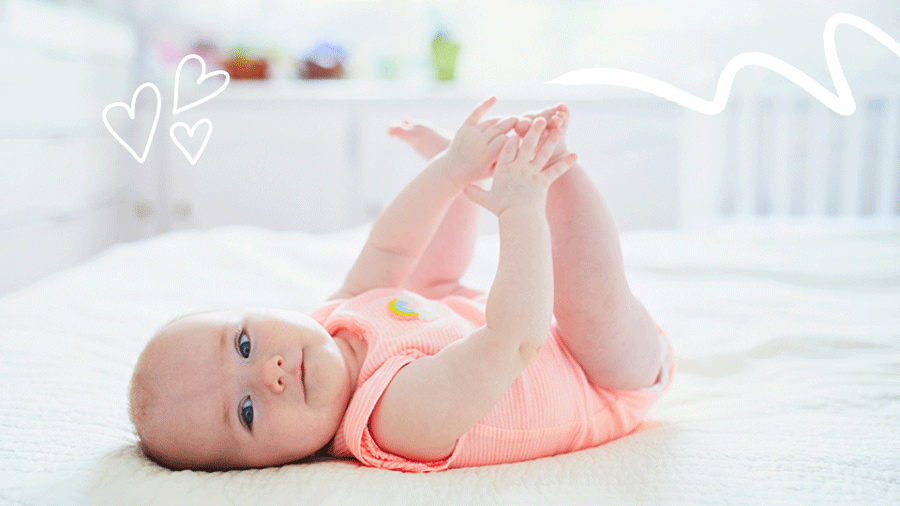6-month-old baby reaches for and plays with their feet