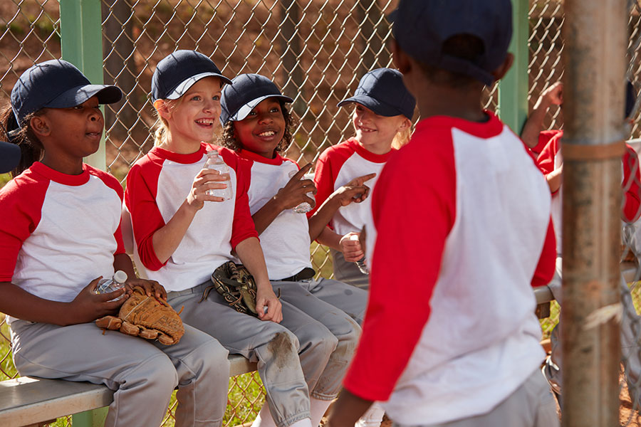 kids drinking water in baseball dugout