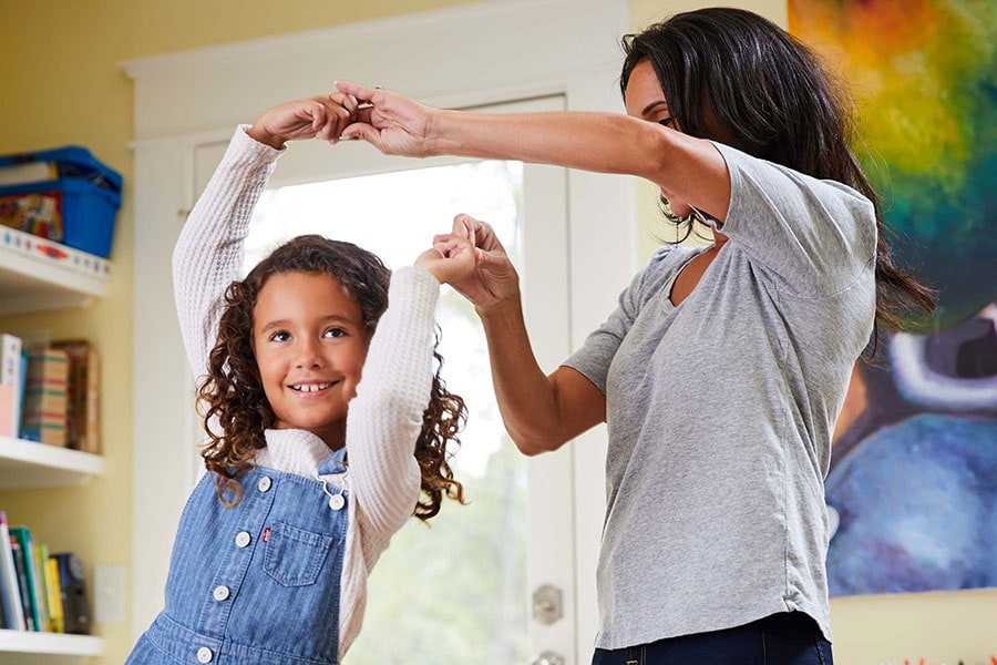 mom and daughter having a dance party in living room