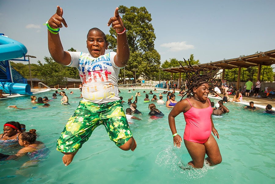 boy and girl campers jumping into pool