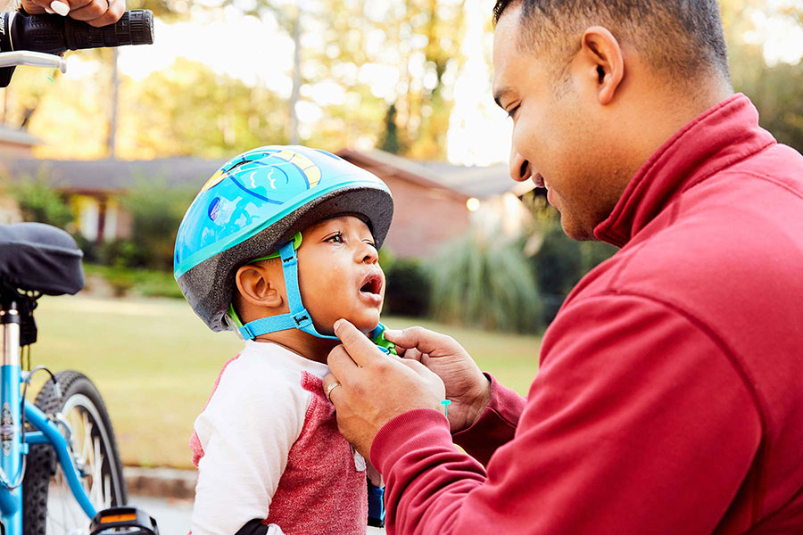 dad consoling son wearing bike helmet
