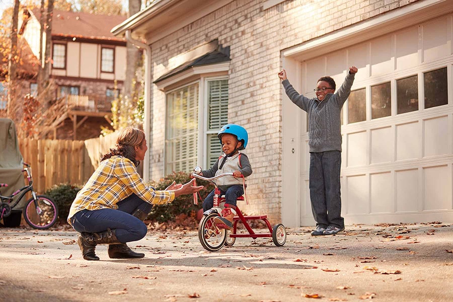 mom helping boy on bike