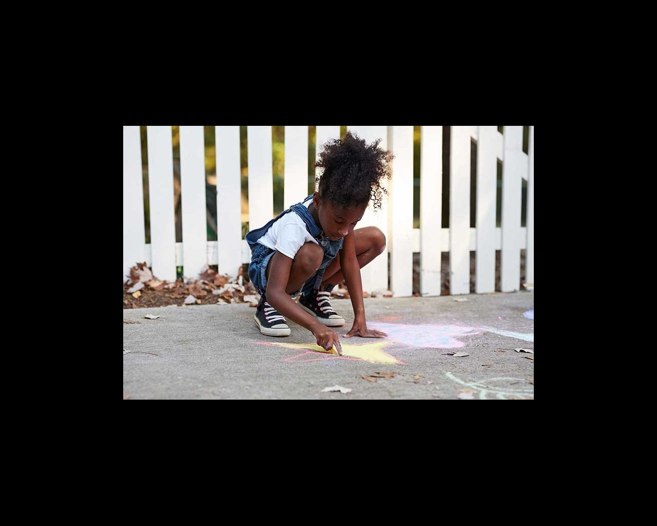 girl drawing with sidewalk chalk