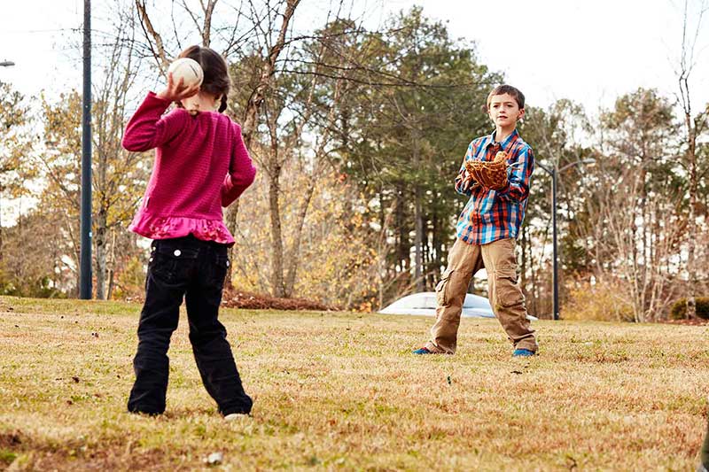 boy playing catch at park