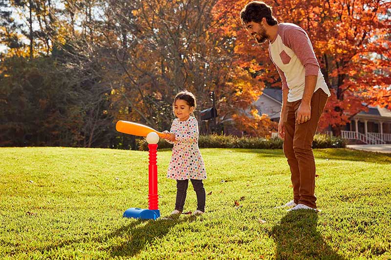 3 year old hitting off tee in yard