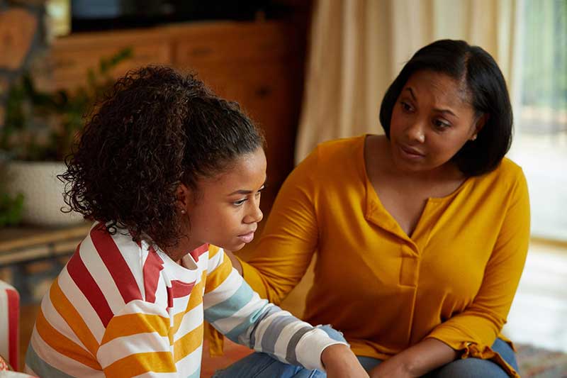 stressed child sitting with parent and talking