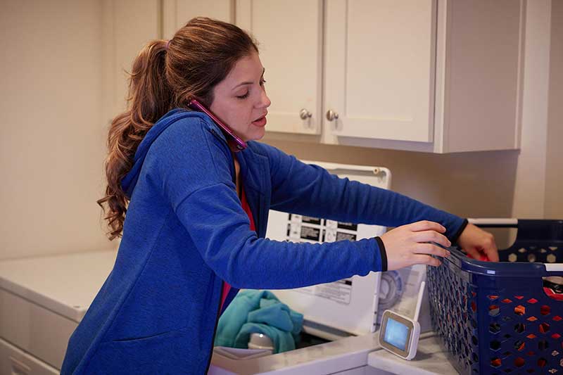 mom talking on phone while doing laundry