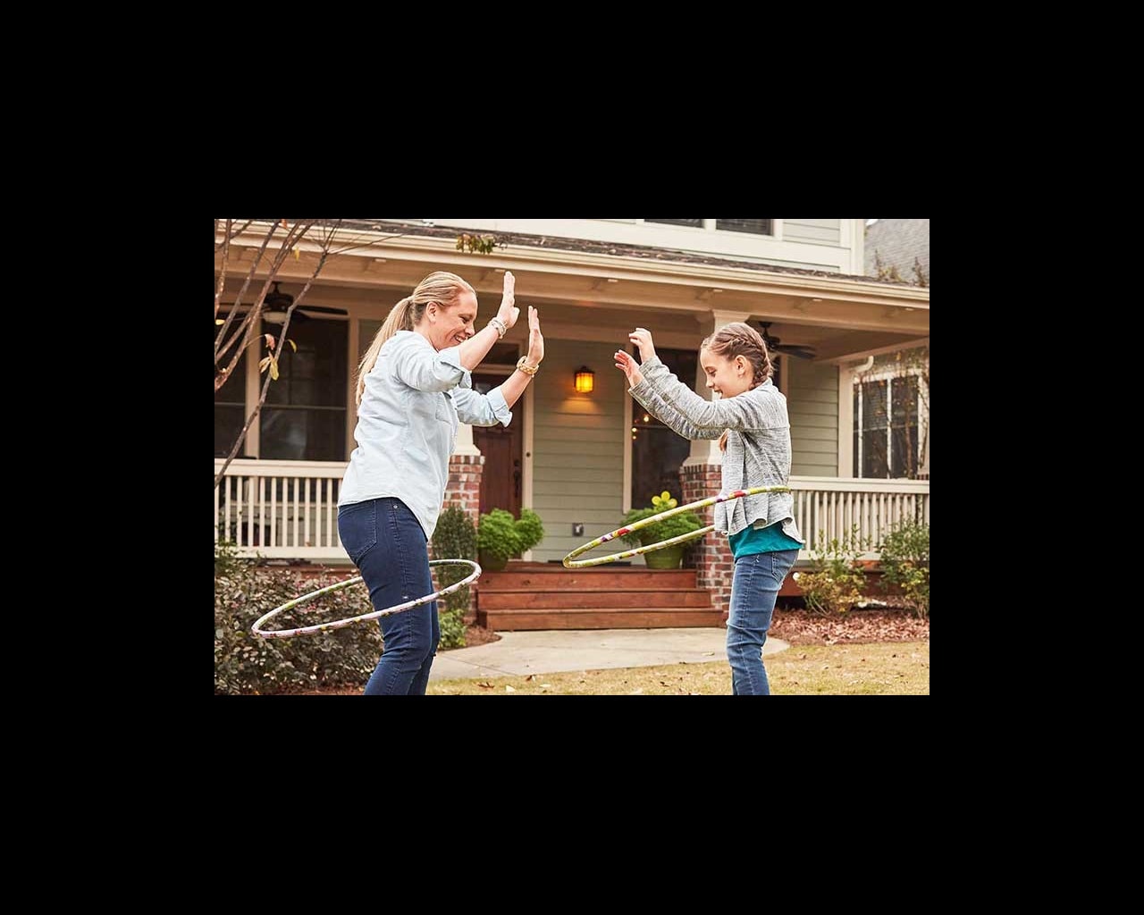 mom and daughter hula hooping outside