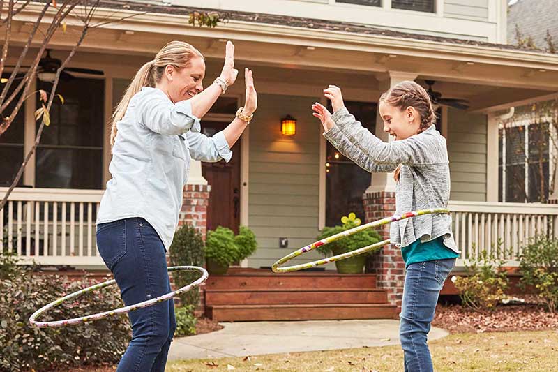 mom and daughter hula hooping outside