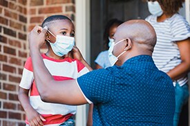dad putting a mask on young son