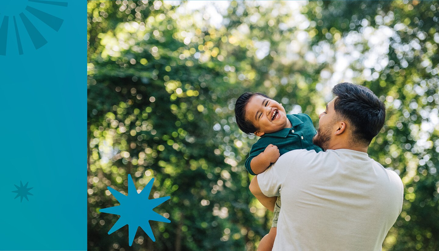 Father holds laughing toddler