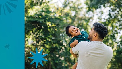 Father holds laughing toddler