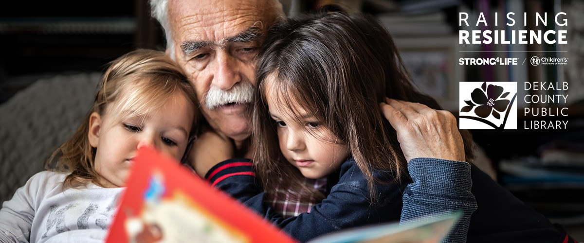 Grandfather reading a book to two young girls