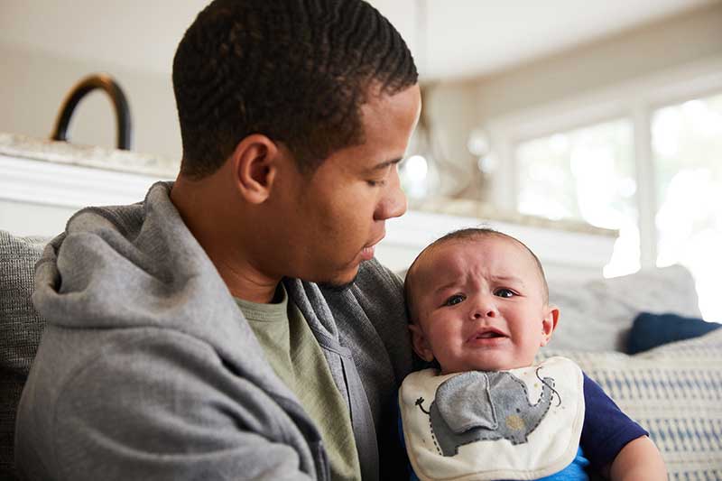 infant crying in parent's arms
