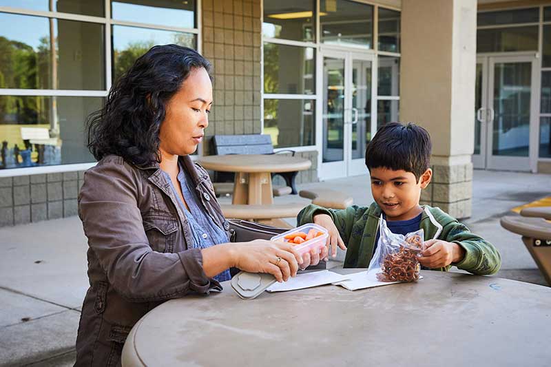 mom and son having snacks outside