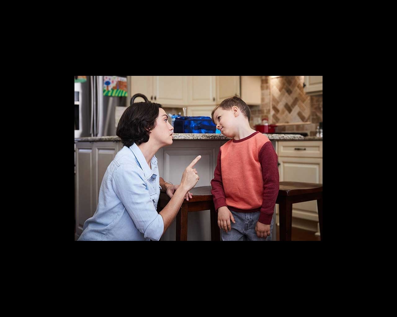 mom wagging finger at son