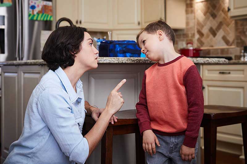 mom wagging finger at son