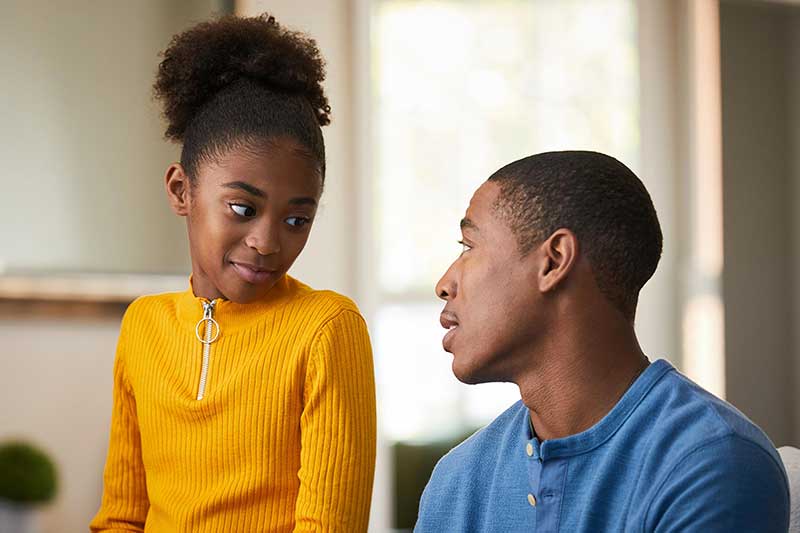 daughter talking to dad on couch