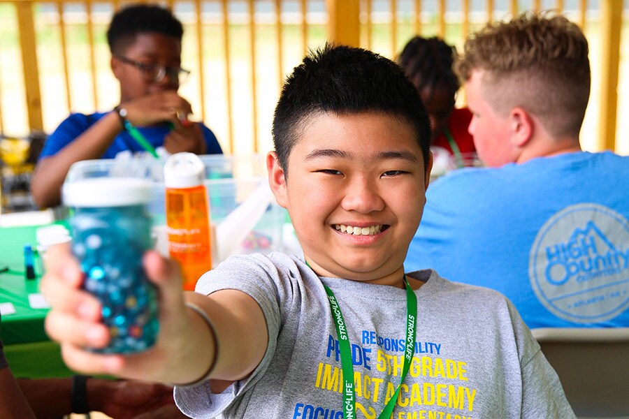 Child proudly showing off the glitter jar he just made