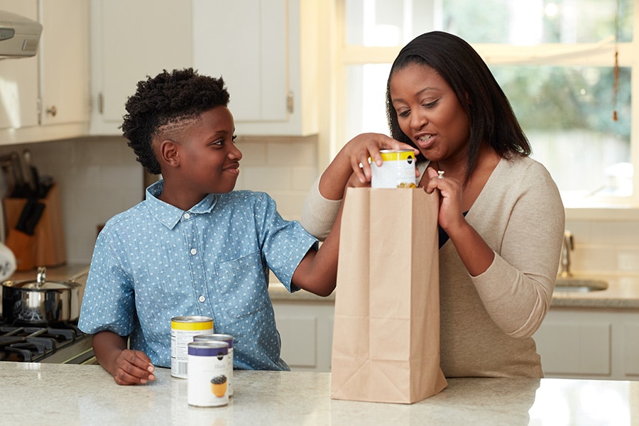 boy and mom gathering canned goods