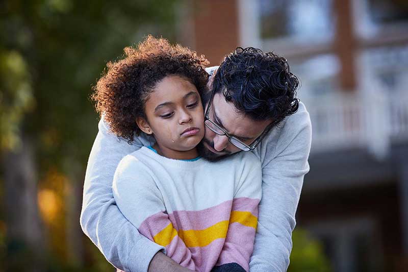 dad hugging tween daughter