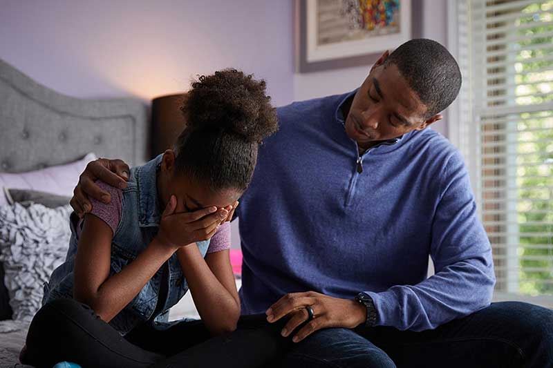 dad comforting crying daughter