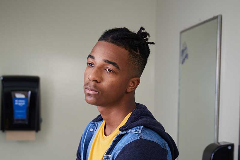 sad teen boy in school bathroom