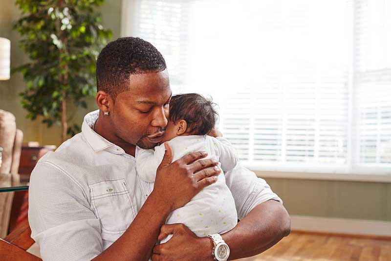 Dad consoling 3-month old girl