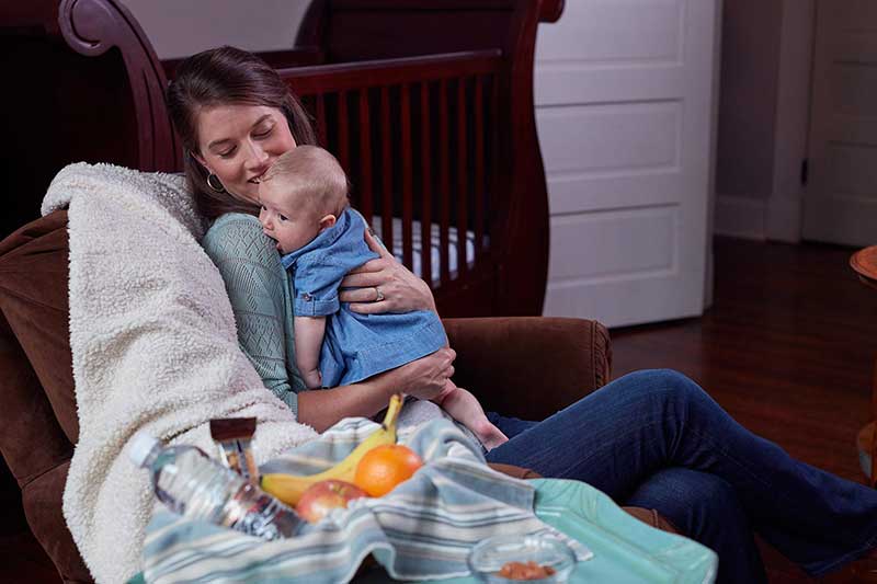 Mom holding rooting infant