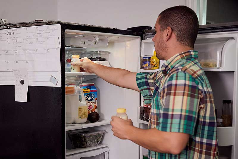 dad putting expressed milk in fridge