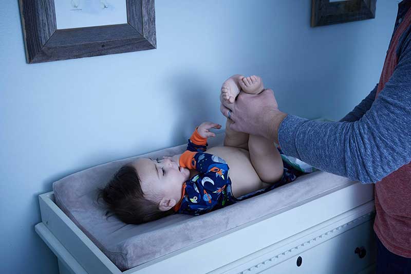 dad changing baby's diaper