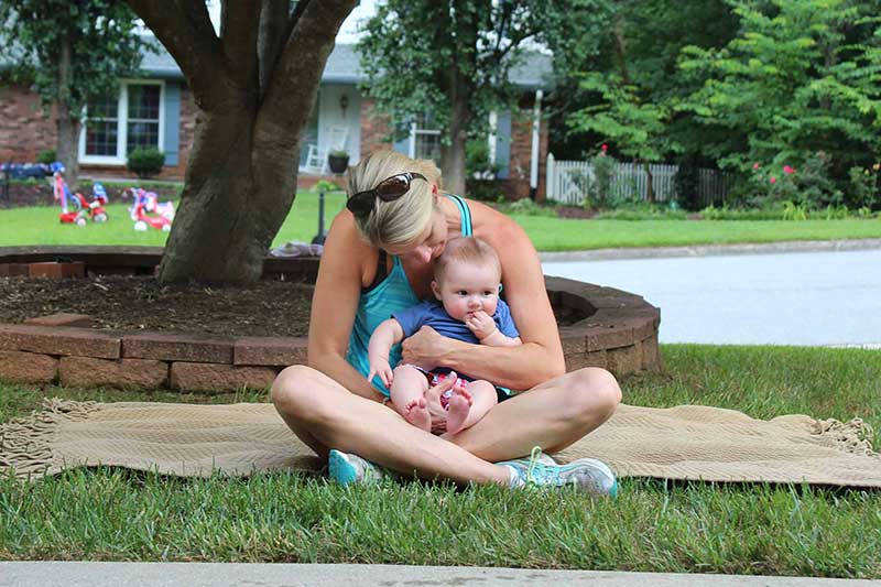 mom sitting under tree with baby